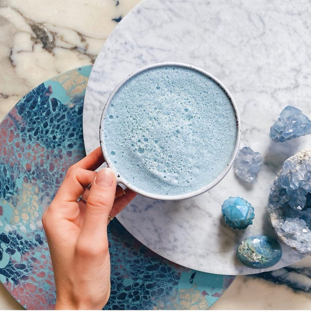 A cup of blue Hada Azul herbal tea by Bosque Encantado. Sustainable and regenerative wellness drink.
